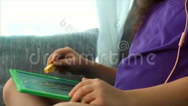 年轻的艺术家，小孩子艺术家用石墨铅笔画画布，坐在桌子上画画布